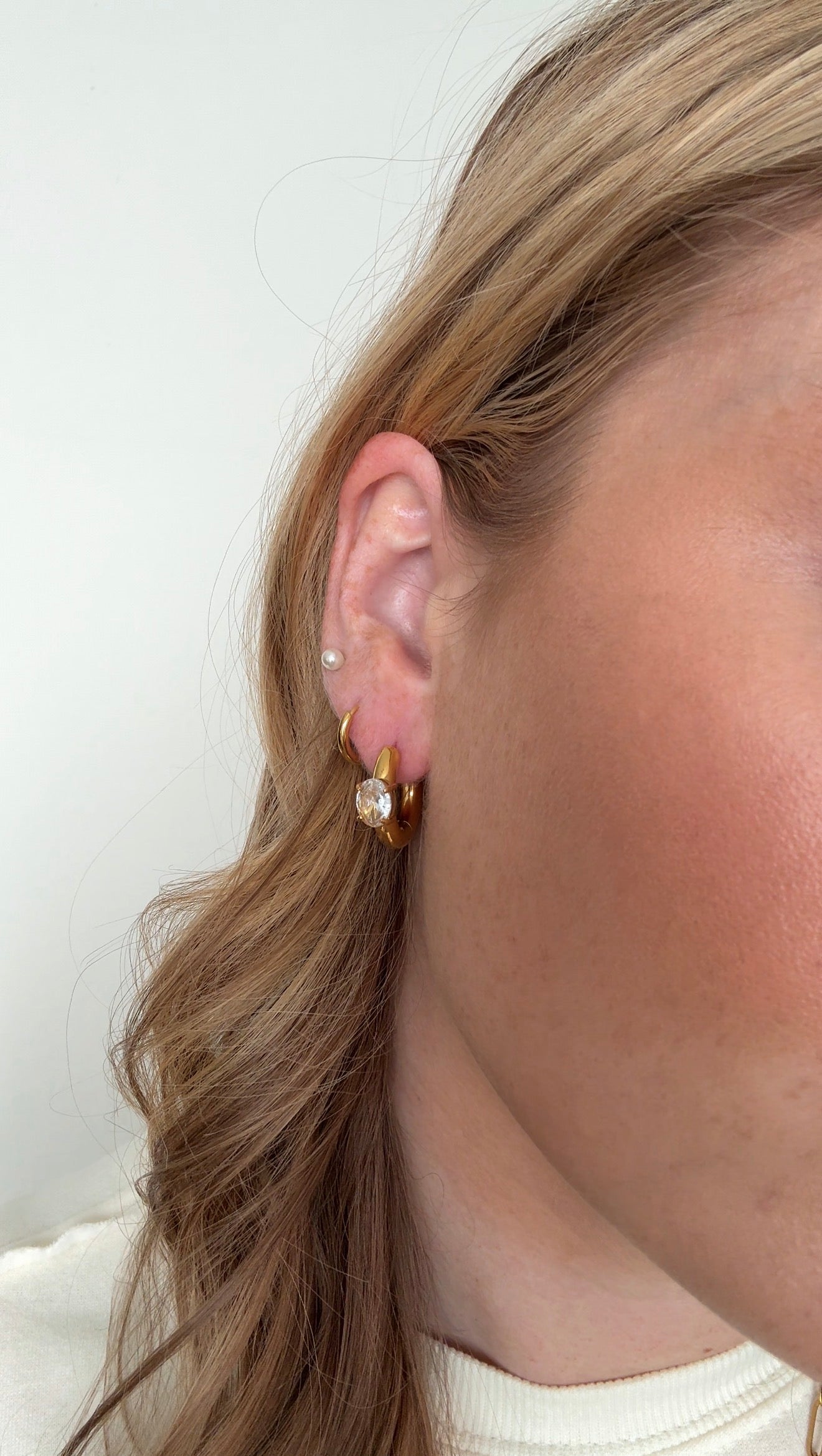Close-up of an ear wearing a small earring with a blurred background